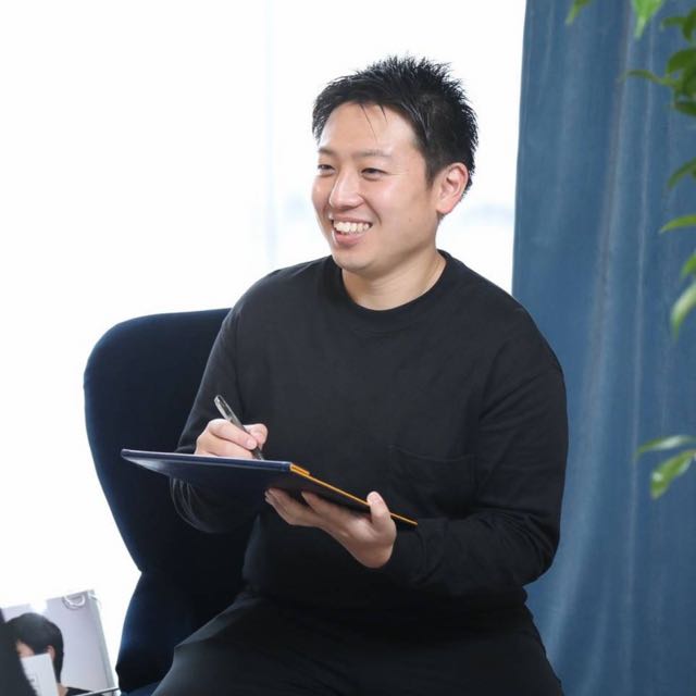 A smiling member of the RESET BASE team, ready to welcome you